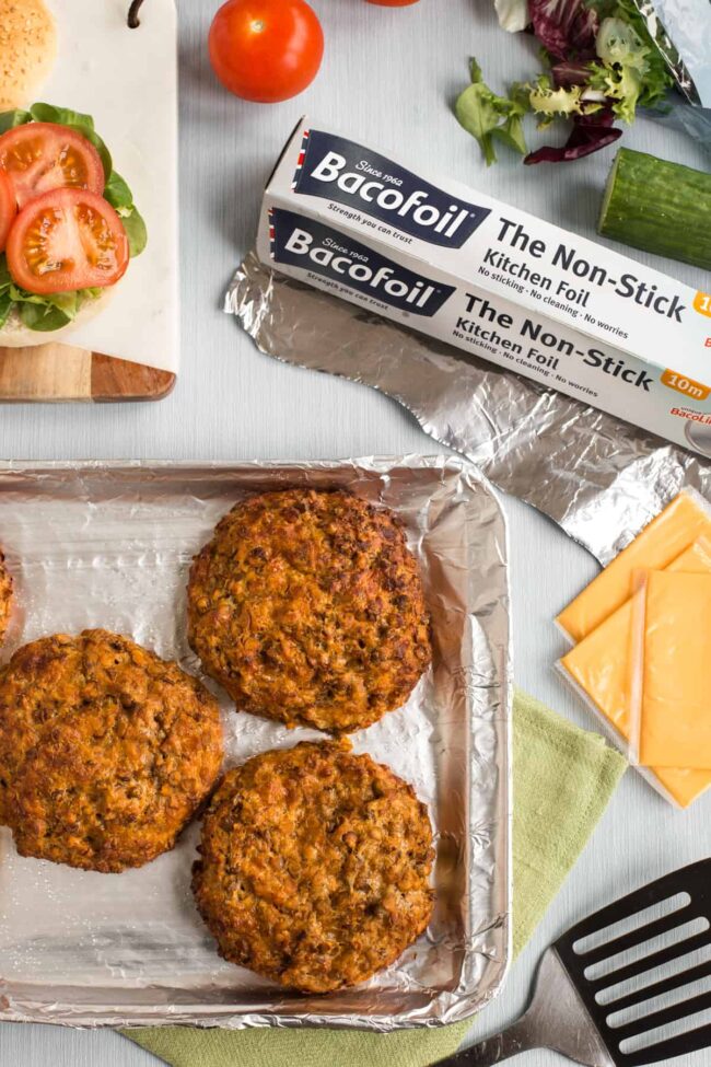 Des burgers aux lentilles croustillants sur une plaque de cuisson, prise de vue du dessus.