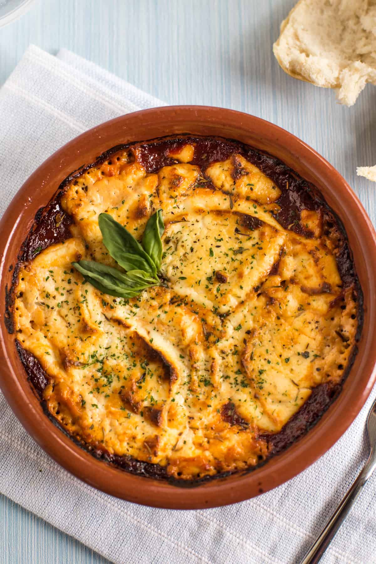 Baked goat's cheese with tomato sauce topped with fresh basil