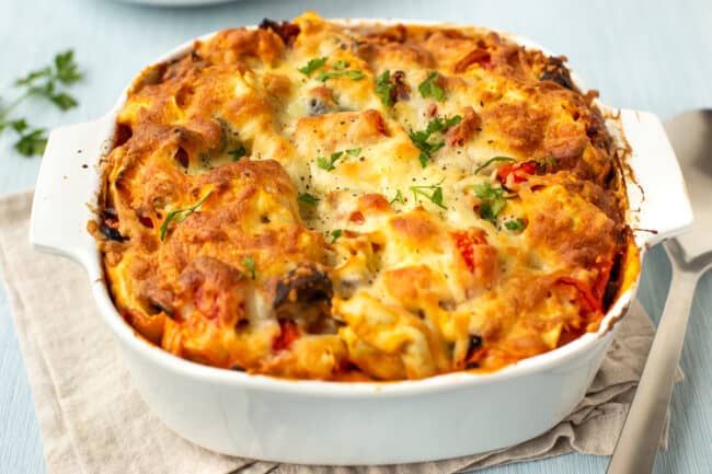 Cheesy pasta bake in a white baking dish.