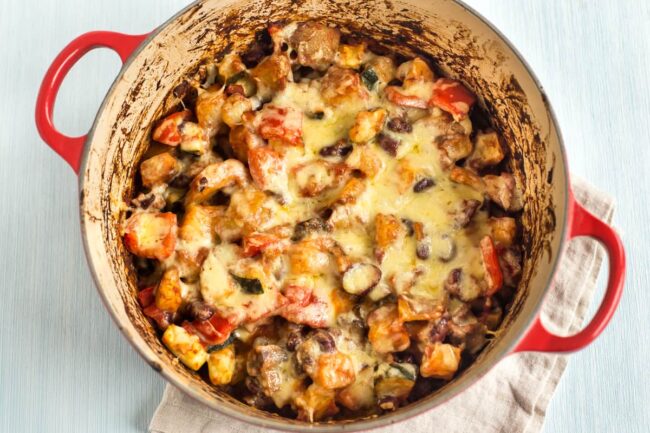 Cheesy bean and potato bake in a large casserole dish.