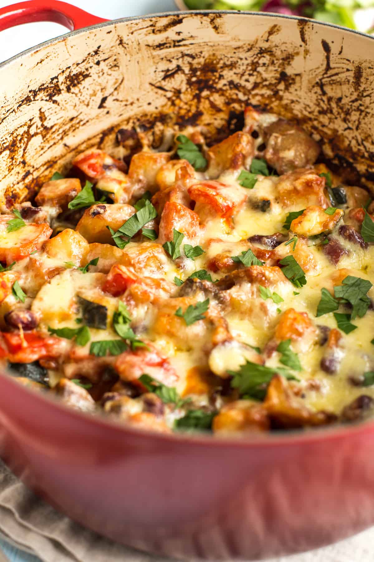 Cheesy Mexican bean and potato bake in a large casserole dish topped with cilantro.
