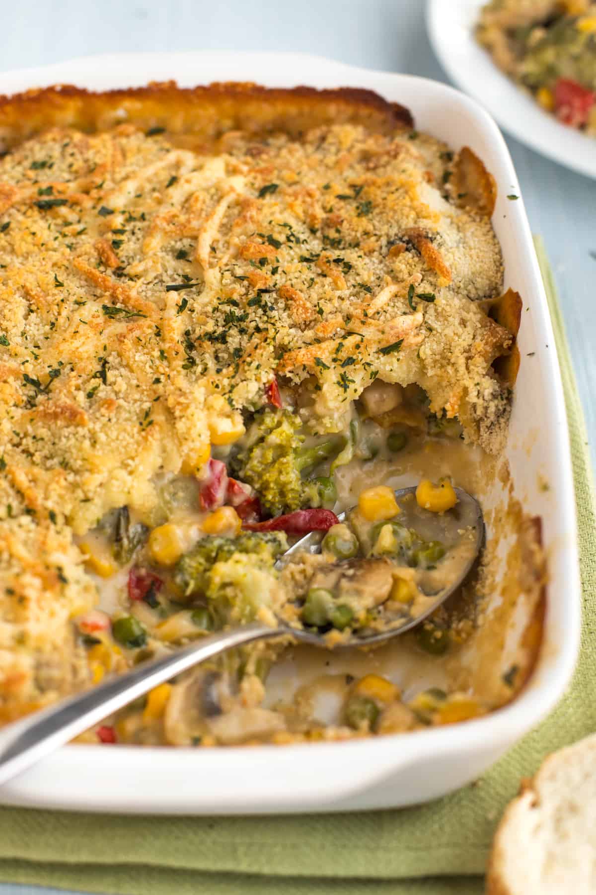 A creamy veggie bake with a large scoop removed, showing the creamy vegetables inside.