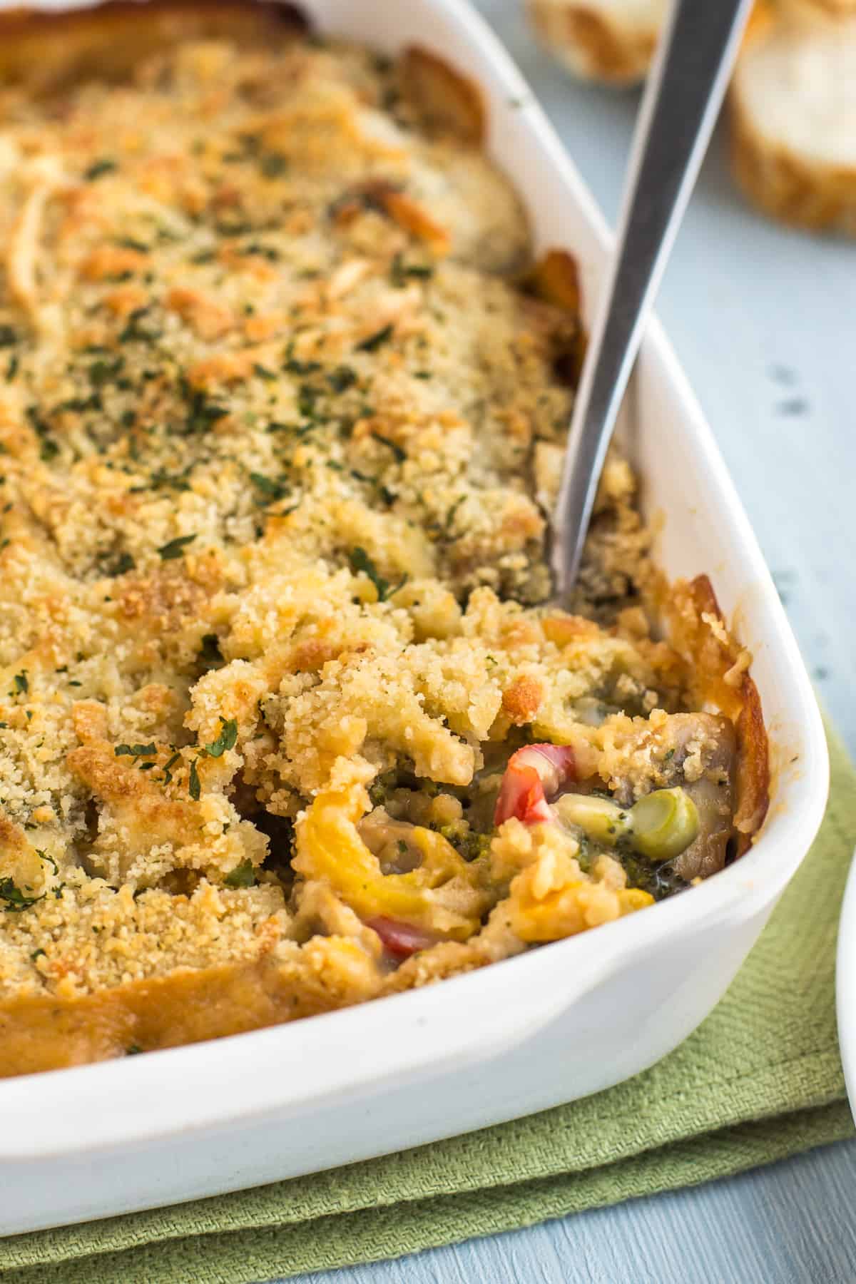 Creamy vegetable bake in a baking dish, with a scoop being removed.