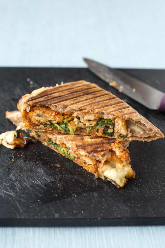 A grilled tortilla cut in half, stuffed with vegetarian nuggets and watercress.