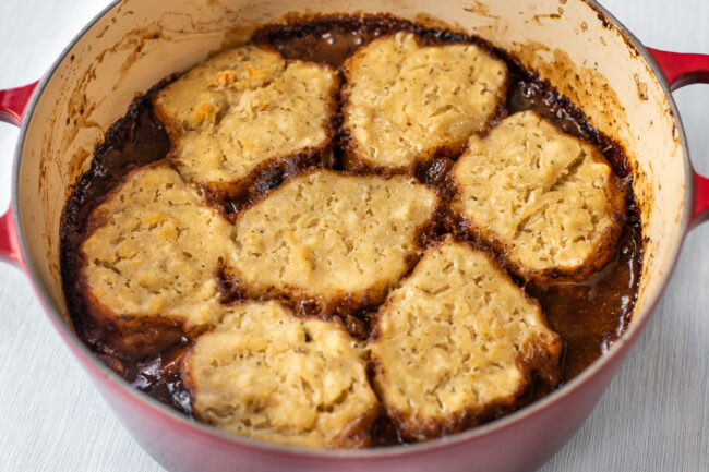 Crispy suet dumplings on top of a pot of stew.