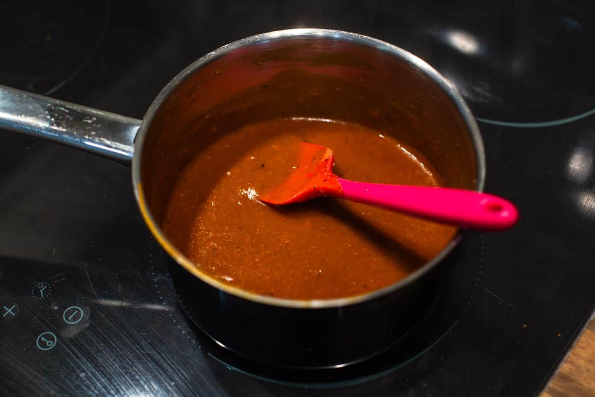 Homemade red enchilada sauce in a small saucepan.