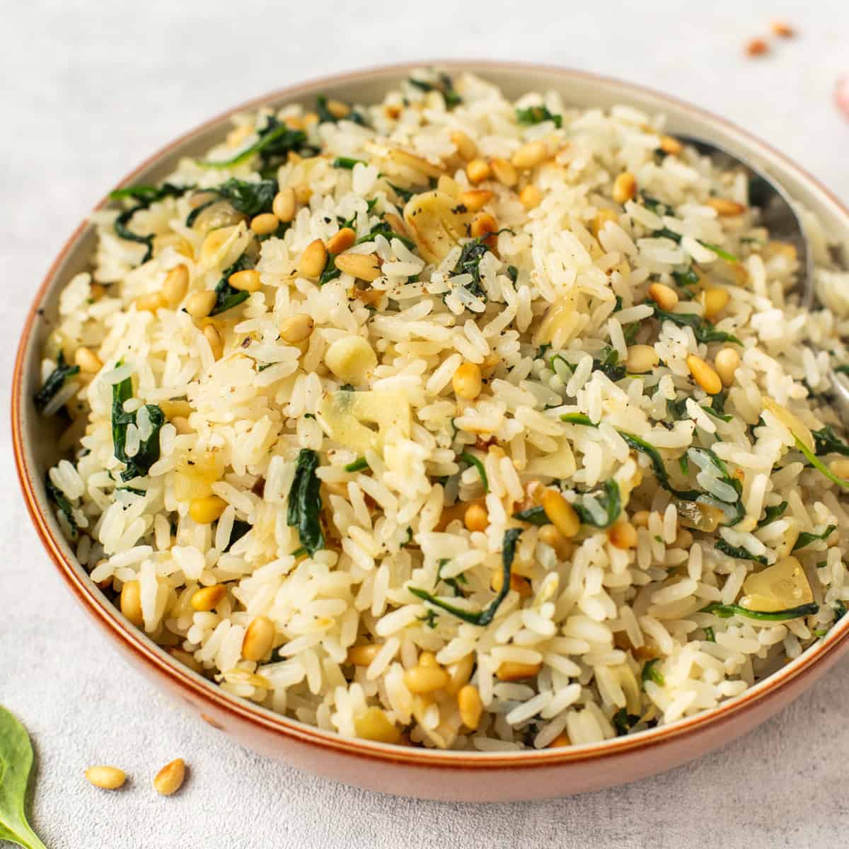 A bowlful of garlicky rice with pine nuts and spinach.