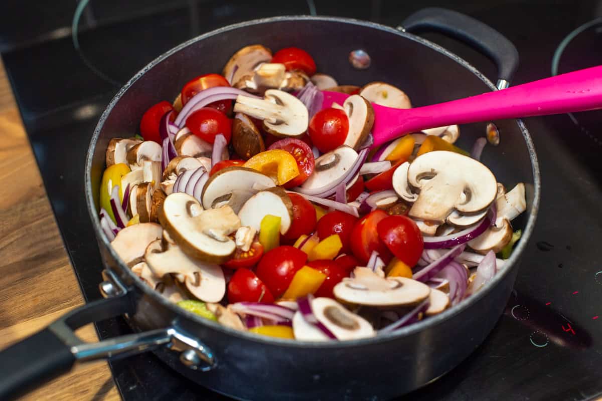 Uncooked Mediterranean vegetables in a frying pan.