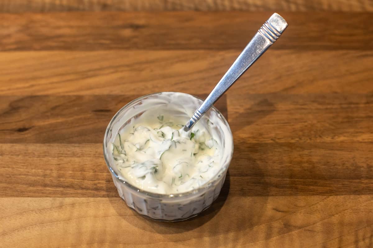 Basil and sour cream mixed in a small bowl.