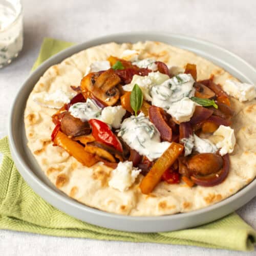 A Mediterranean vegetable flatbread on a plate.