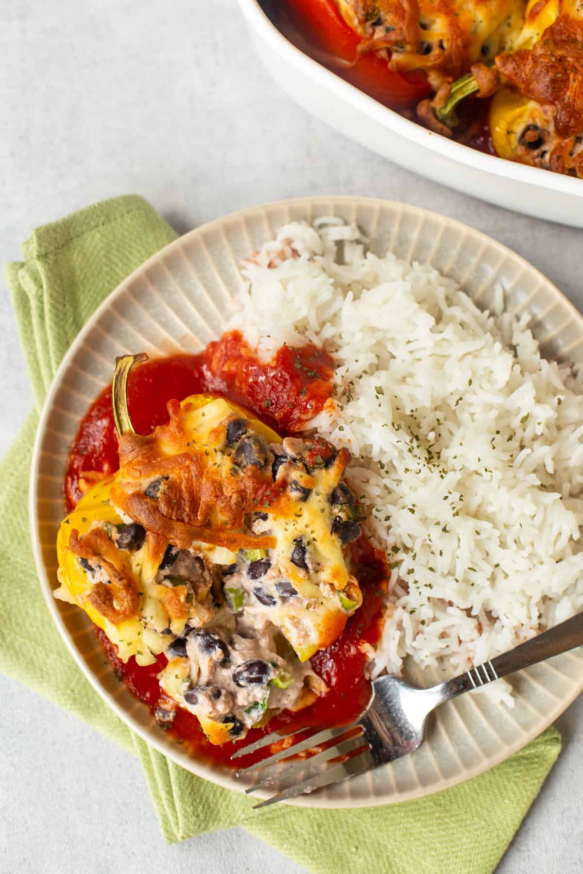 Overhead shot of a ricotta stuffed pepper with black beans and rice.