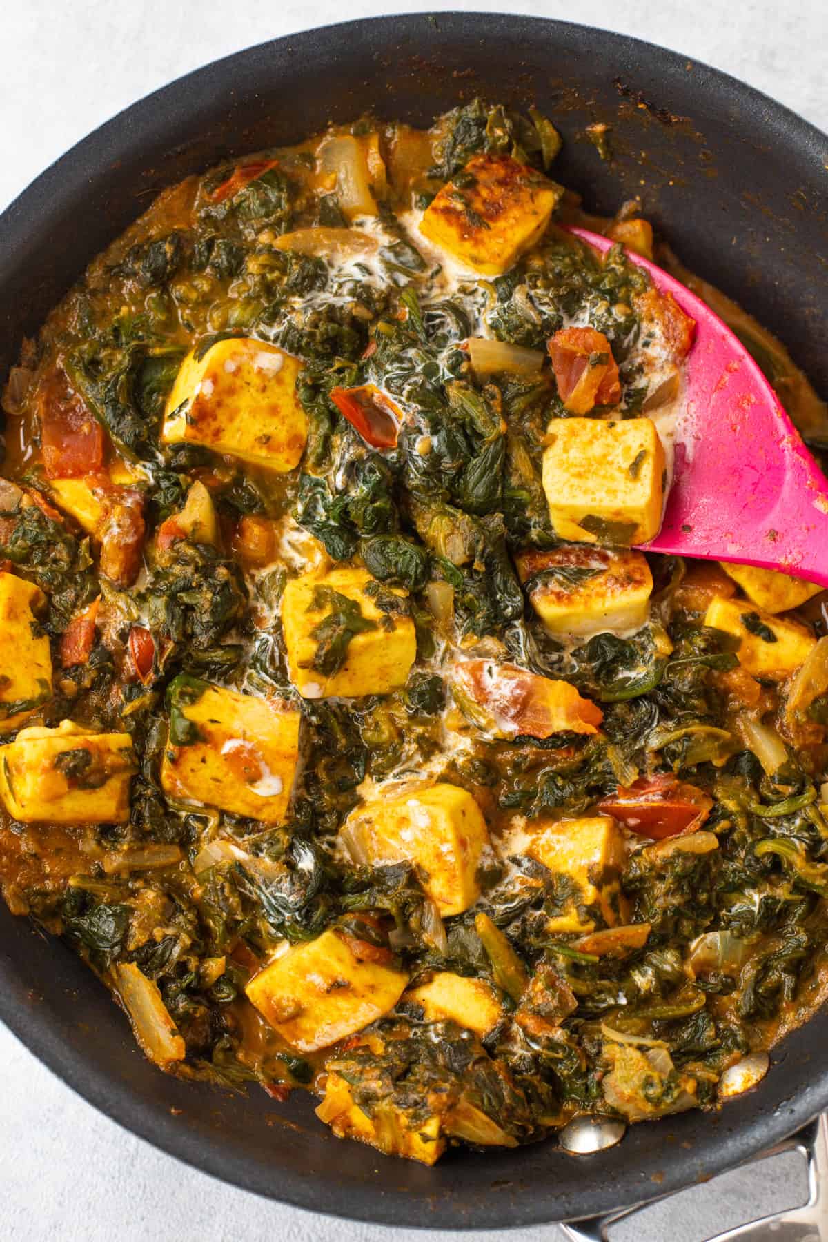 Creamy saag paneer (spinach and paneer curry) in a frying pan.