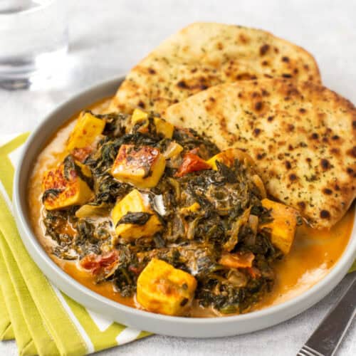 A portion of saag paneer with naan bread.