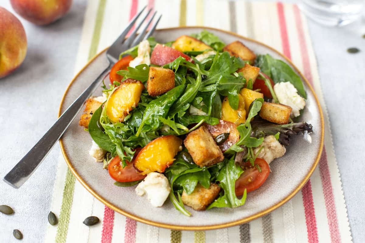 A plate with a portion of peach and mozzarella salad.