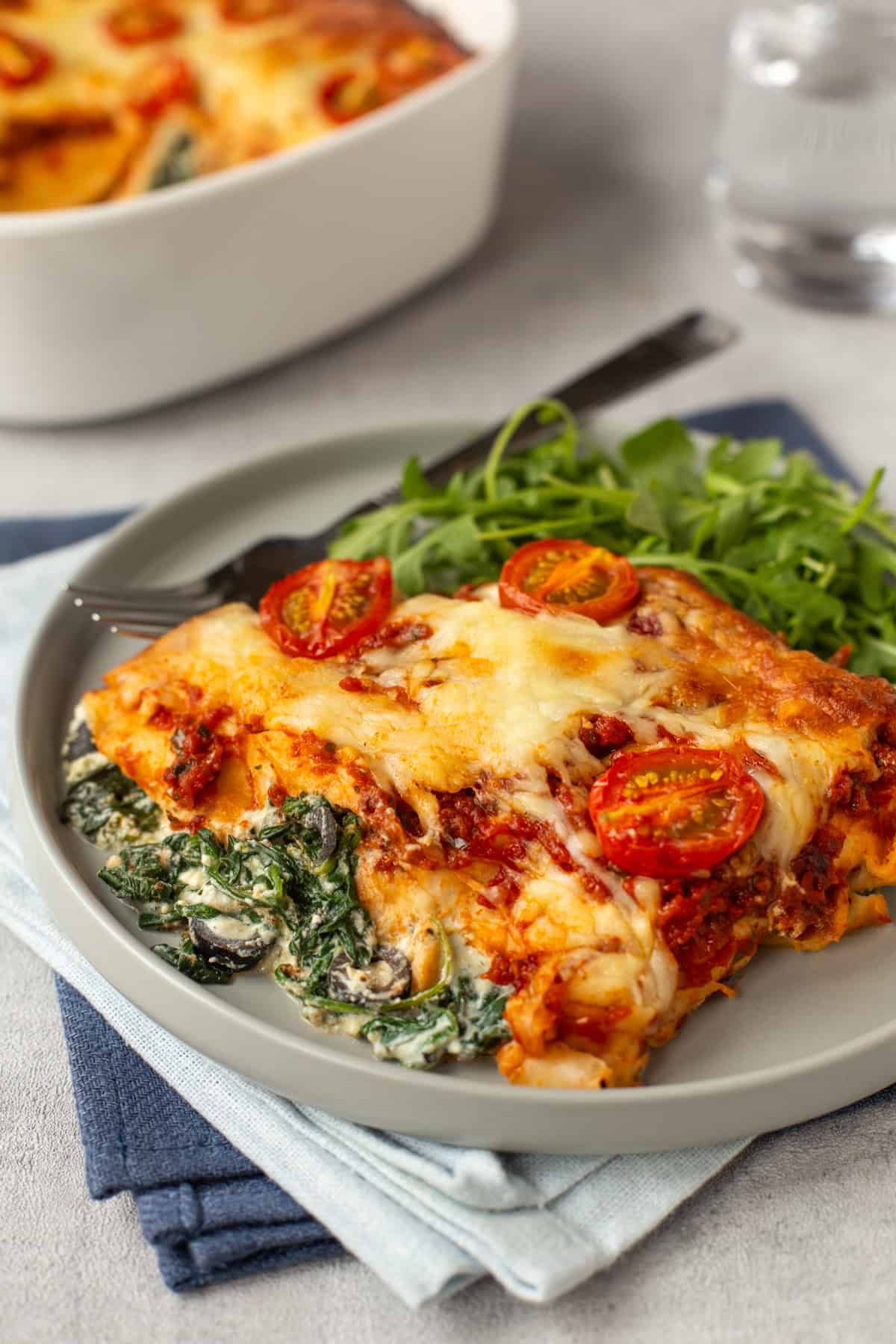 Spinach and ricotta enchiladas on a plate with arugula.