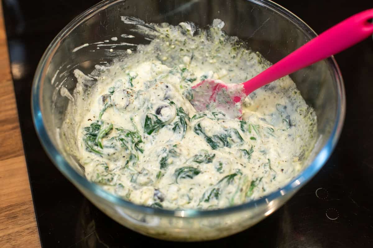 Creamy spinach and ricotta mixture in a mixing bowl.