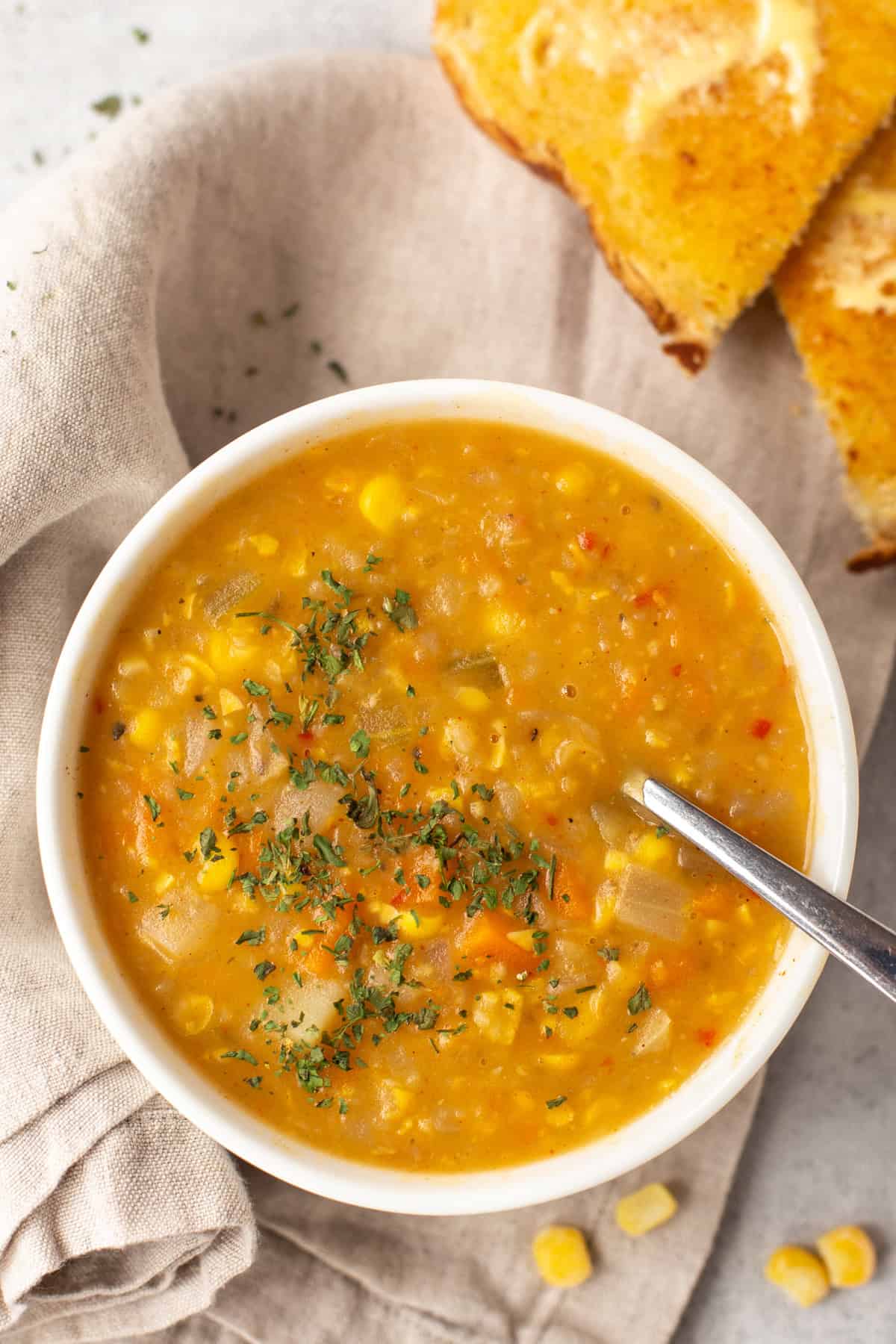 Overhead shot of vegan corn chowder with buttered toast.