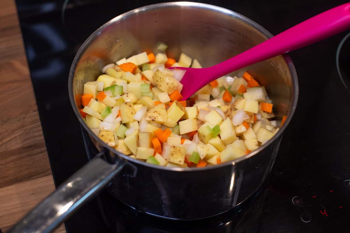 Diced potatoes and other vegetables in a saucepan.