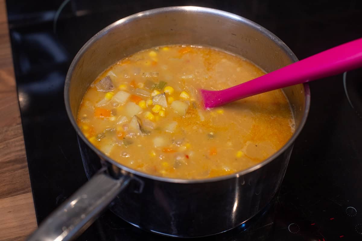 Chunky corn chowder in a saucepan.