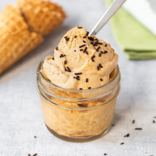 A small bowlful of pumpkin pie ice cream with sprinkles.