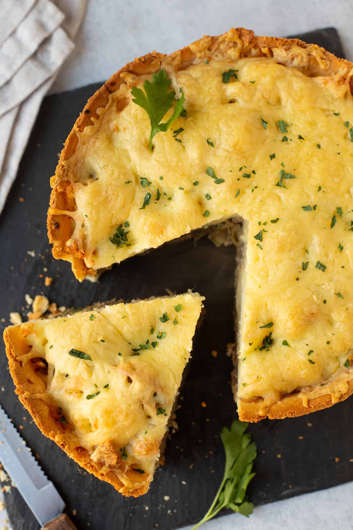 Overhead shot of a cheesy pie with a slice pulled away.