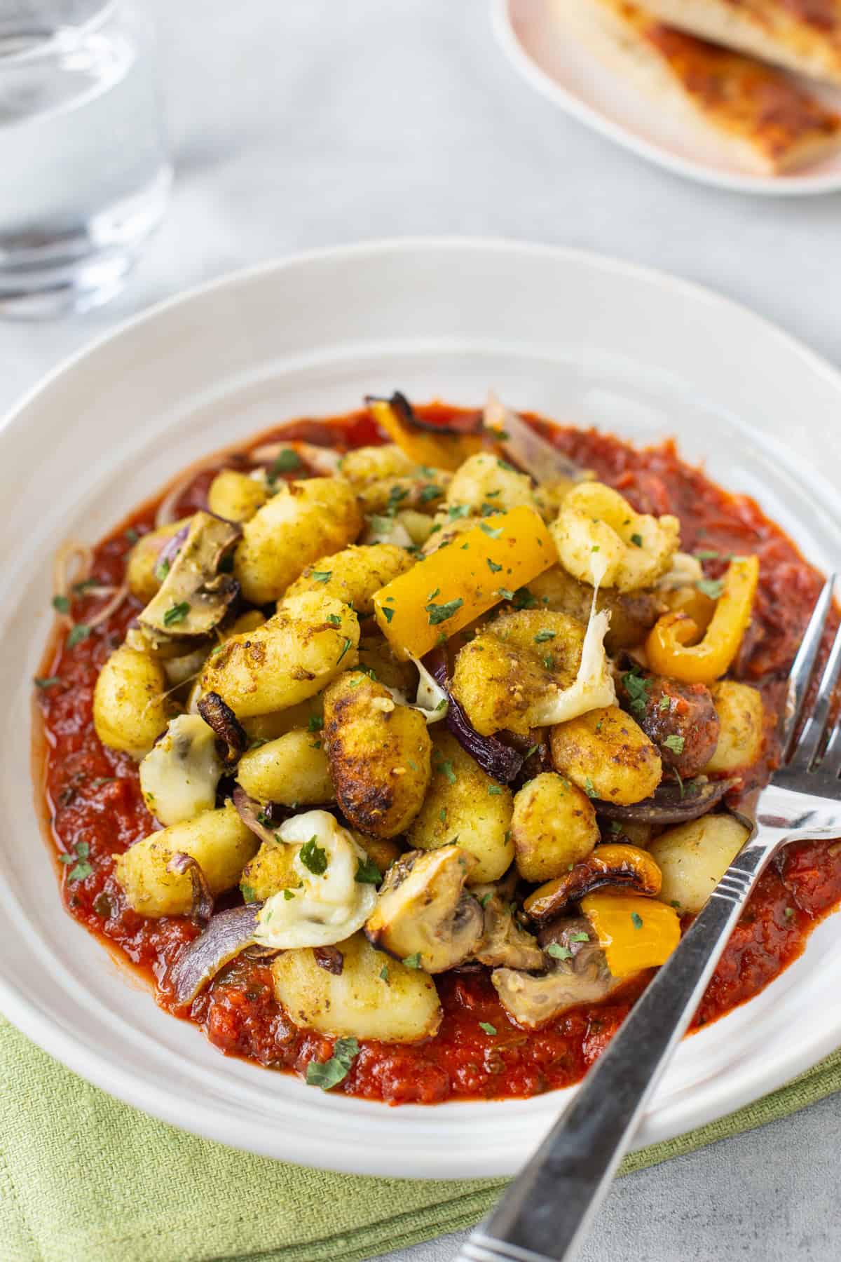 Air fryer gnocchi and vegetables with mozzarella and pesto.