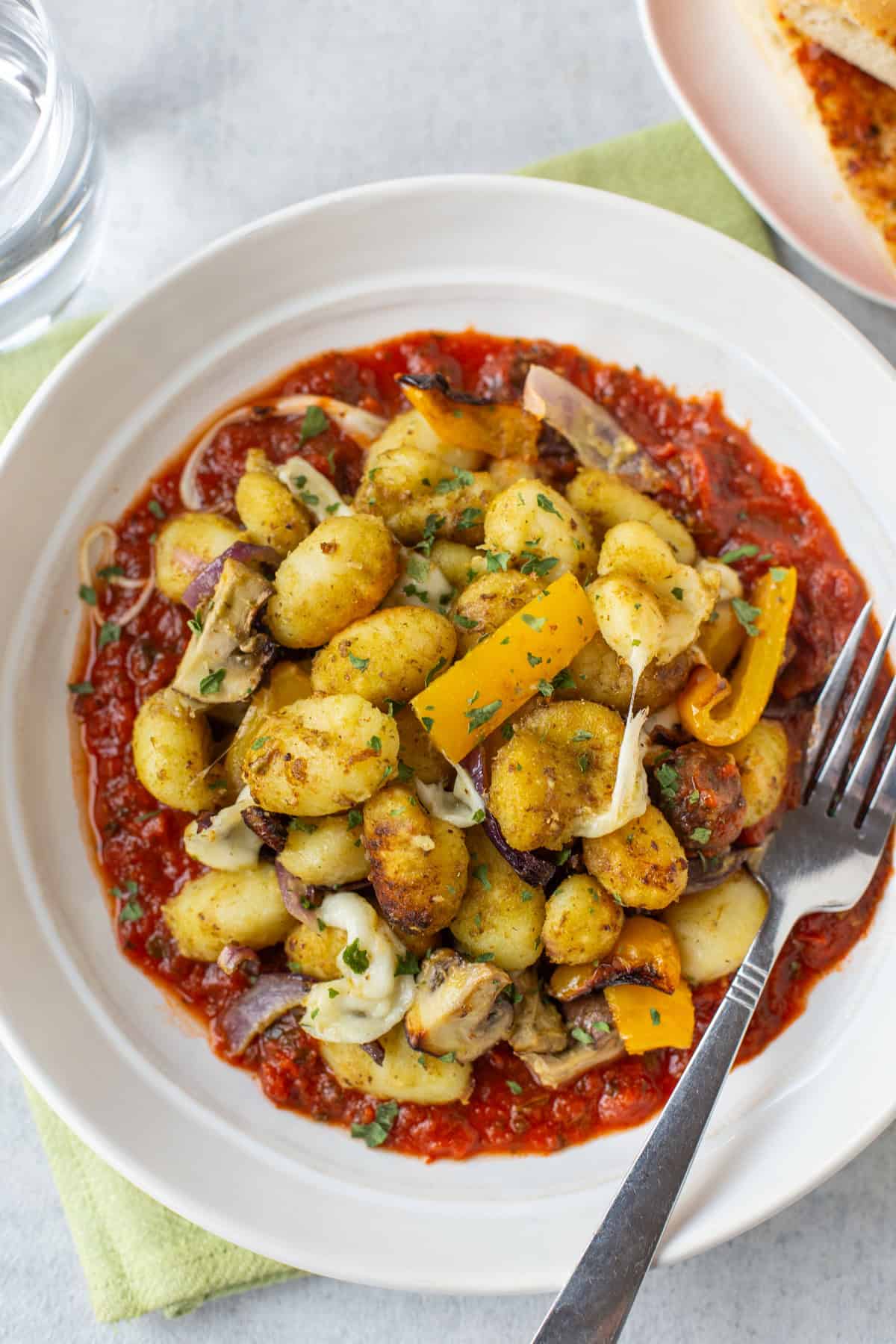 A bowl of air fryer gnocchi on tomato sauce.