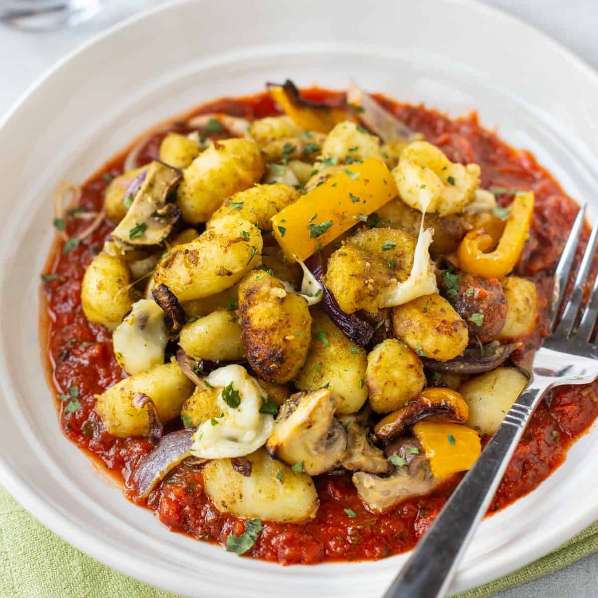 Air fryer gnocchi and vegetables on tomato sauce.