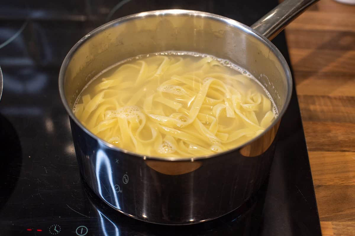 Cooked tagliatelle in a saucepan of water.